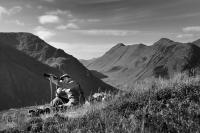 Black Corries, Glencoe. Deer stalker spying through telescope for stags. Black and white