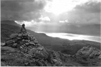Stone cairn, Loch Torridon, atmospheric sky. Black and white.